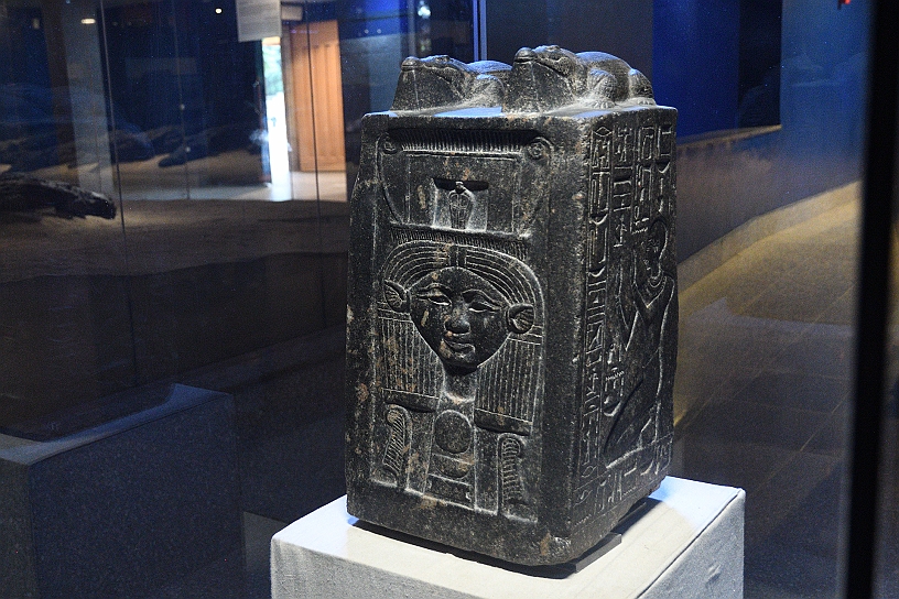 89 MAK_6424.jpg - Infine un blocco votivo in granodiorite raffigurante il sacerdote Nebnefer, databile al regno di Amenofi III (1391-1353 a.C.) sulla parte anteriore la dea Hathor, sulla sommità due coccodrilli, simbolo del dio Sobek, ai lati Nebnefer in atto di pregare.